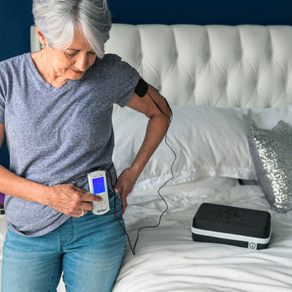 iReliev TENS unit for pain relief and recovery, shown in a lifestyle setting with a portable device and electrode pads.