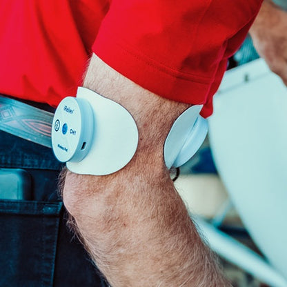 iReliev wireless large single pads refill kit for TENS and EMS devices, shown in a lifestyle setting with reusable gel pads.