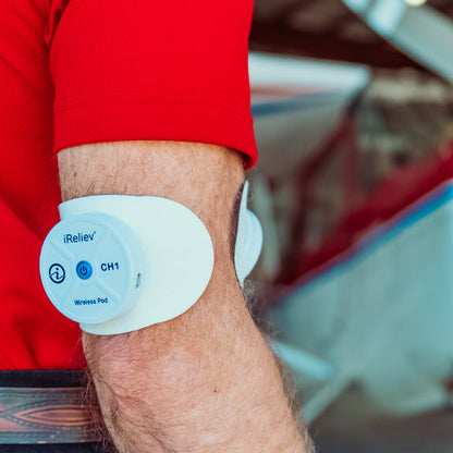 iReliev wireless electrode pads refill kit with large and small pads for TENS and EMS therapy, shown in a lifestyle setting