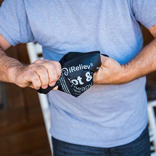 iReliev reusable hot and cold therapy gel pack with securement straps, shown in a lifestyle setting for pain relief and recovery.