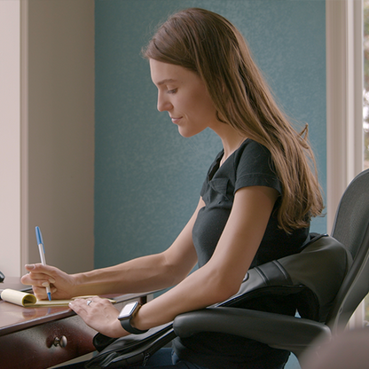iReliev Shiatsu Neck and Back Massager used on a person's neck and shoulders in a home setting, highlighting its design and comfort.