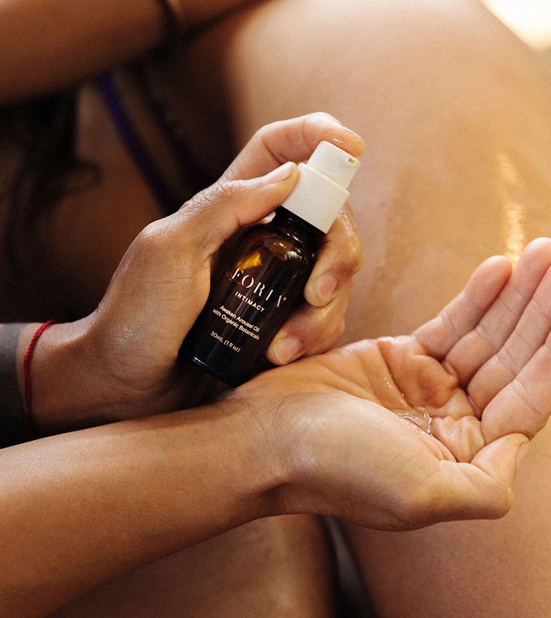 Foria Awaken Arousal Oil with organic botanicals shown in a natural lifestyle setting, highlighting the product's intimate use.