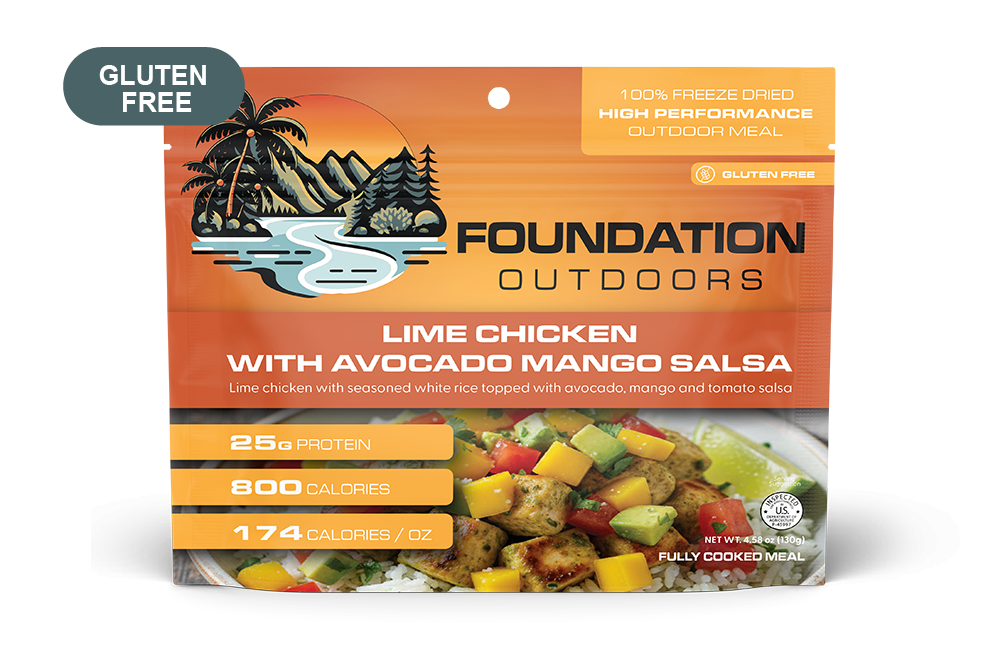 Grilled lime chicken meal with sliced avocado and vibrant mango salsa on a plate, served with fresh herbs.