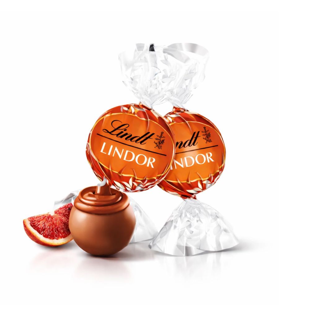 Lindt Lindor blood orange milk chocolate truffles in a bulk bag, showcasing smooth chocolate and vibrant orange filling.