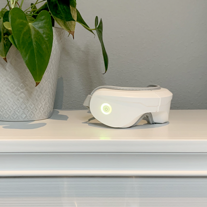 iReliev Relaxable™ Eye Massager with Heat showing a person wearing the massage device around the eyes, providing soothing relief.