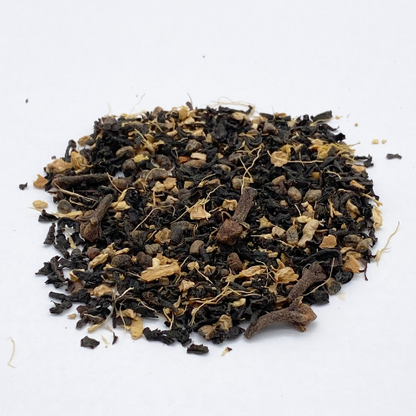 Loose leaf Masala Chai black tea blend from Novel Tea Book Shop, showcasing aromatic spices and dark tea leaves.