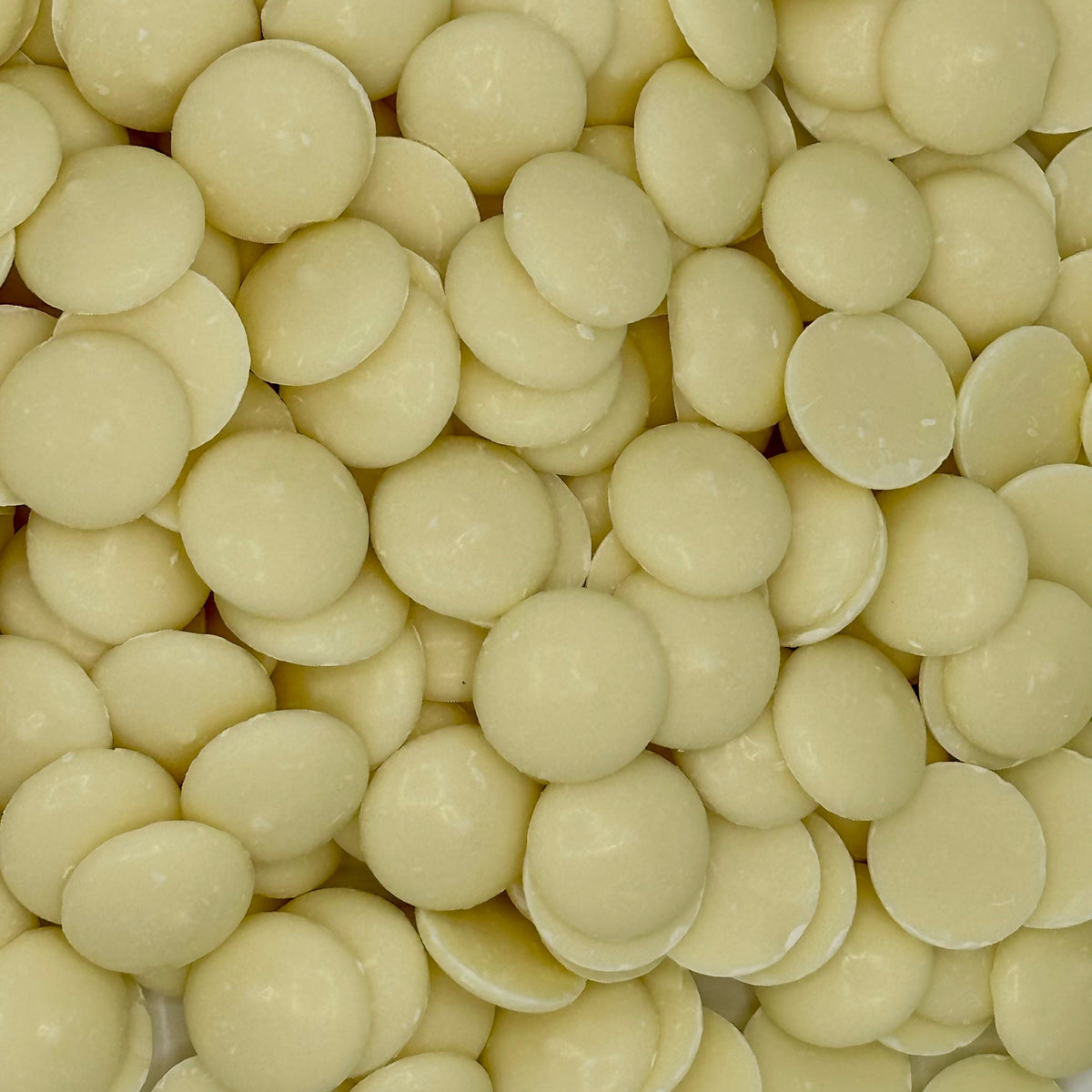 White vanilla-flavored Merckens chocolate coating and melting wafers in a bulk bag, ideal for candy making and baking.