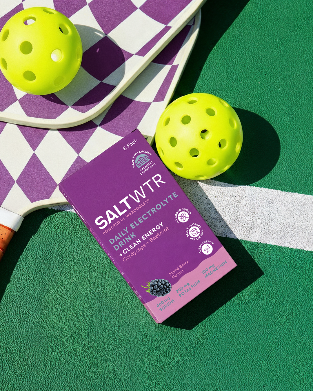 SaltWTR Mixed Berry Clean Energy SaltWTR beverage on a padel court, showcasing vibrant mixed berry flavor in a clear bottle.
