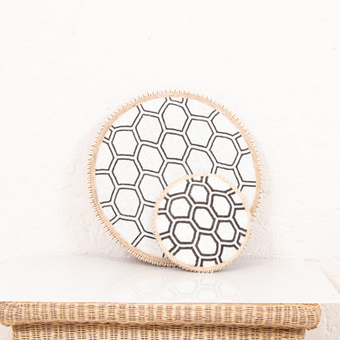 Beaded Cameroon shield in black and white on stand with hexagon light design, used as a stylish home decor piece.