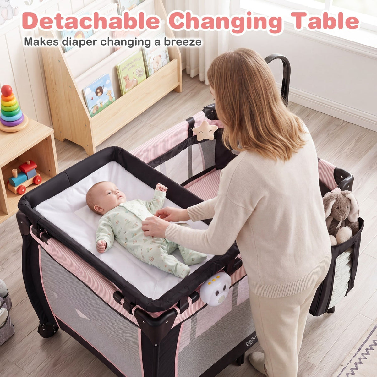 Pink baby playpen with changing table and bassinet, featuring soft padding and safety rails for infants and toddlers.