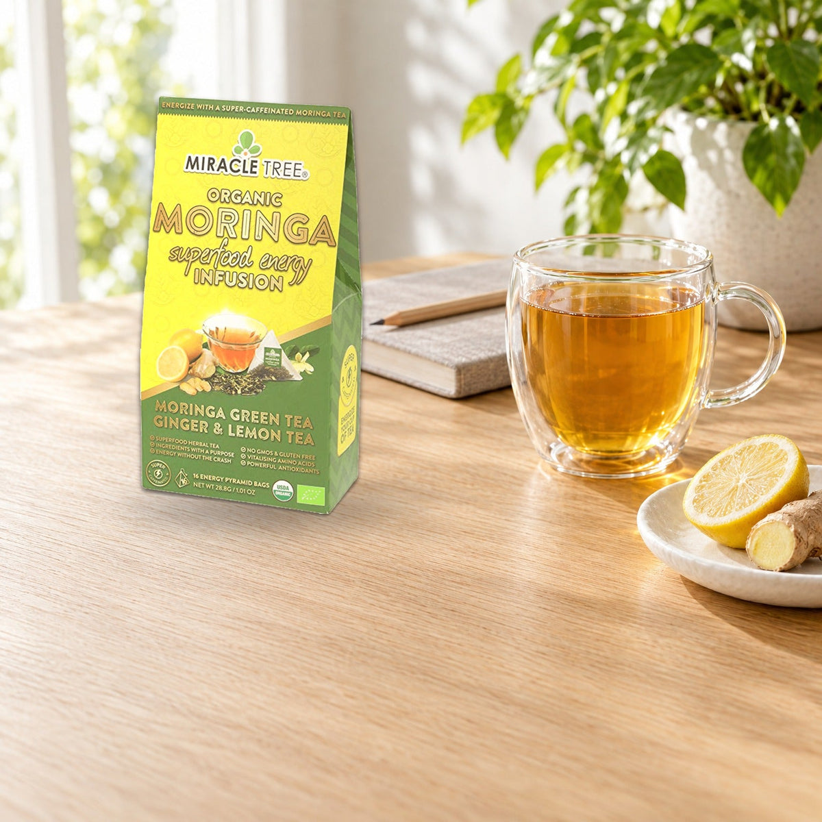 Organic Moringa Energy Tea by Miracle Tree with ginger and lemon, natural coffee alternative, served in a clear glass mug.