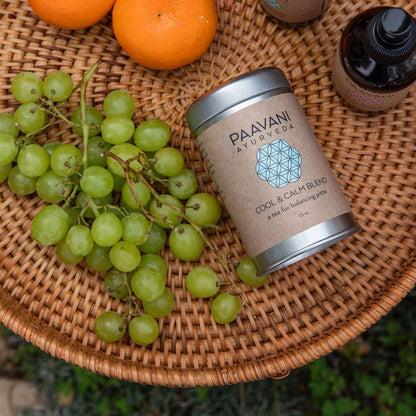 Paavani Ayurveda Cool & Calm Blend Ayurvedic tea for Pitta balance in a clear glass cup with herbs and tea leaves.