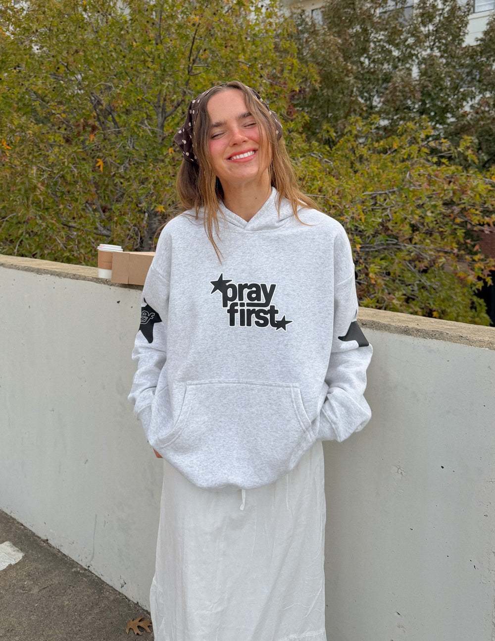 Elevated Faith Pray First unisex hoodie with front graphic and comfortable fit, made from soft fabric for casual wear.