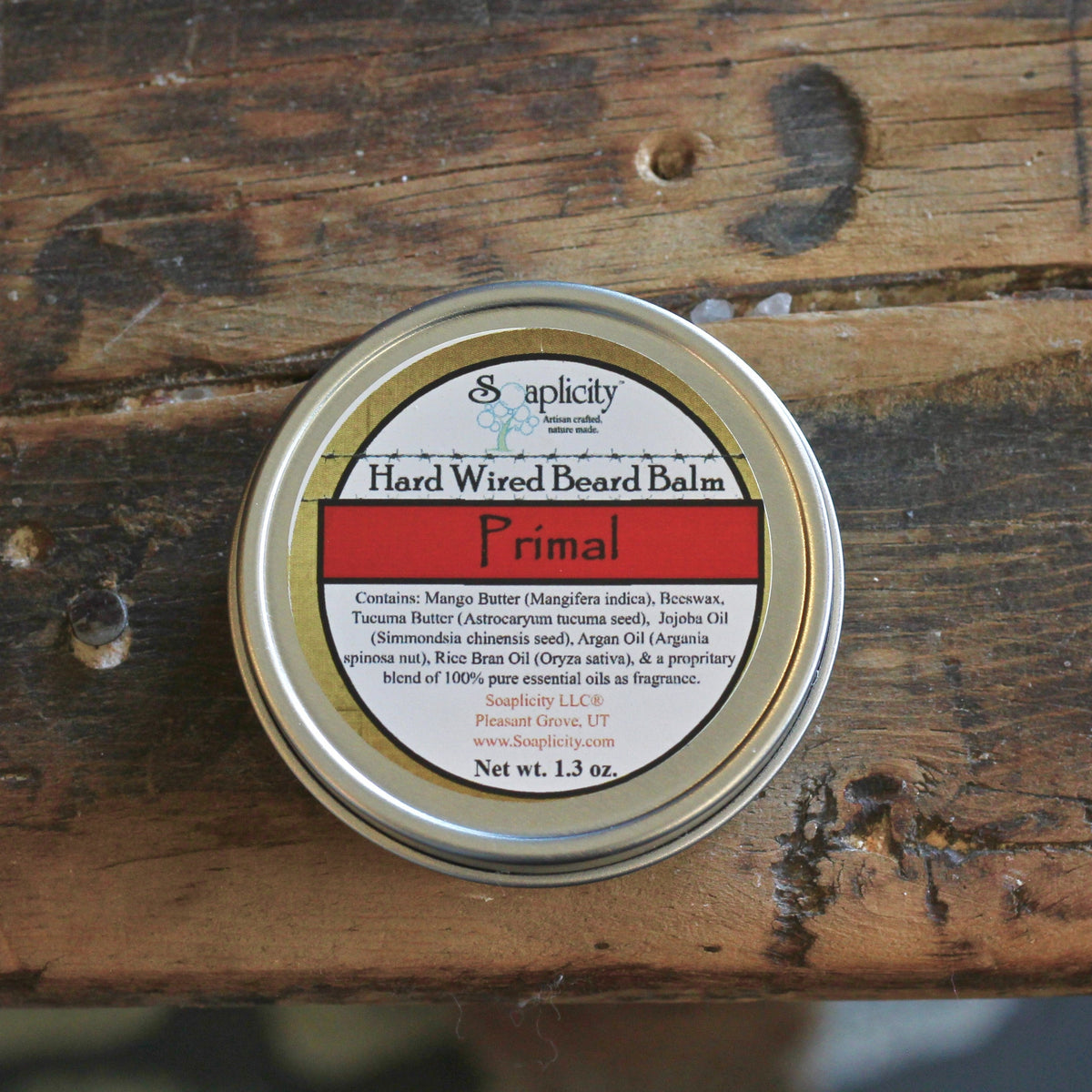 Primal Hard Wired Beard Balm by Soaplicity, a natural beard balm in a tin container, with a smooth, creamy texture for grooming.
