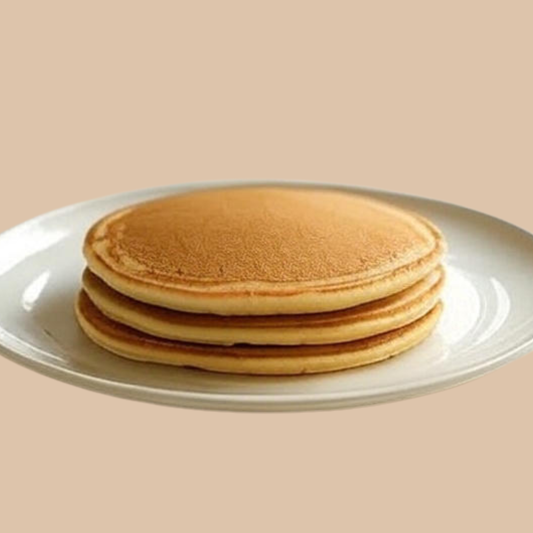 Stack of AmBari Nutrition protein pancakes, fluffy hot cakes topped with syrup and fresh fruit, ready to serve.