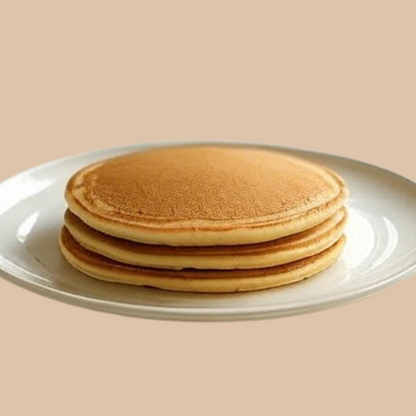 Stack of AmBari Nutrition protein pancakes, fluffy hot cakes topped with syrup and fresh fruit, ready to serve.