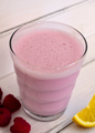 AmBari Nutrition Lemon Raspberry Shake featuring a glass filled with a vibrant lemon raspberry protein shake and fresh fruit garnish