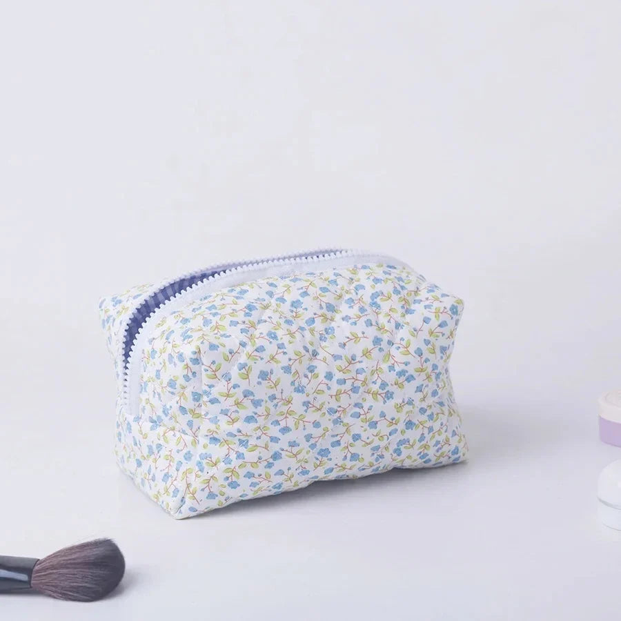 Blushimmer floral quilted makeup bag with large floral print, puffy design, and multiple compartments for travel cosmetics and accessories.
