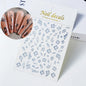White and black 3D hibiscus flower nail stickers with pink and gold accents, adhesive floral decals for nail art decoration.