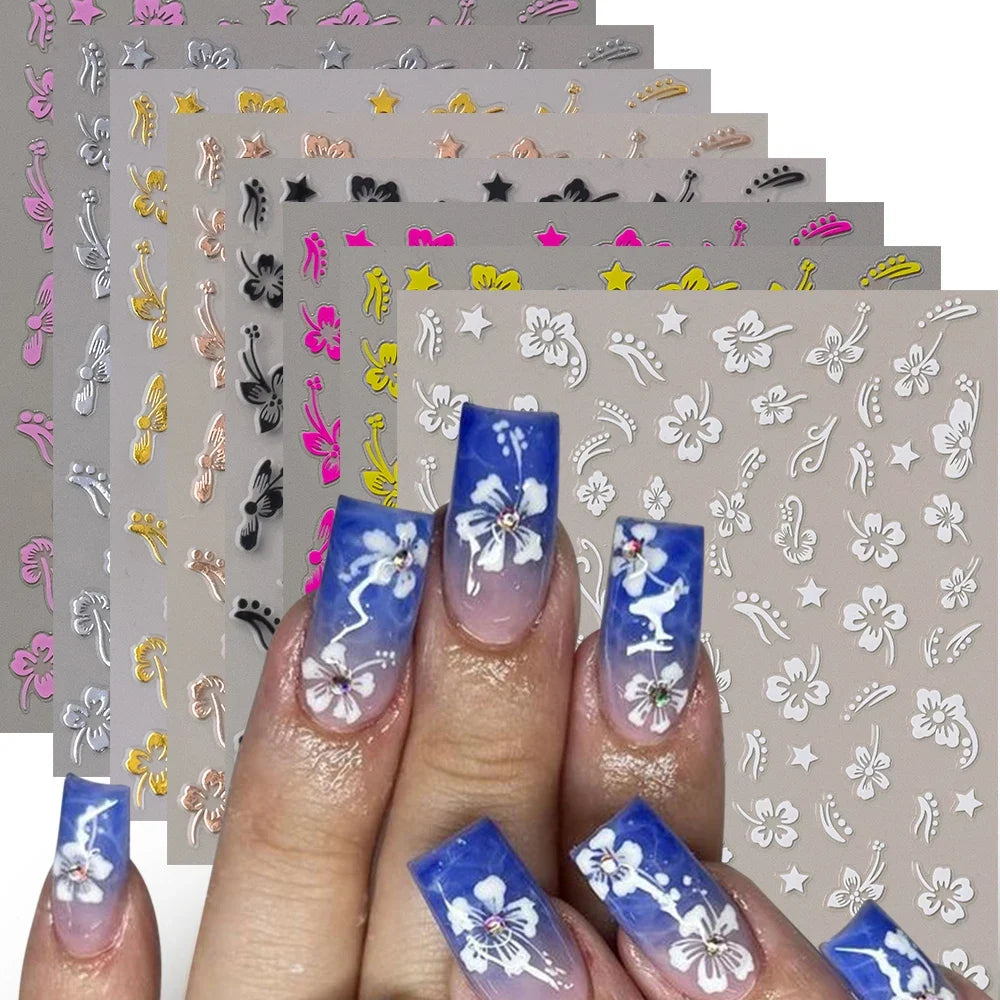 White and black 3D hibiscus flower nail stickers with pink and gold accents, adhesive floral decals for nail art decoration by Blushimmer.