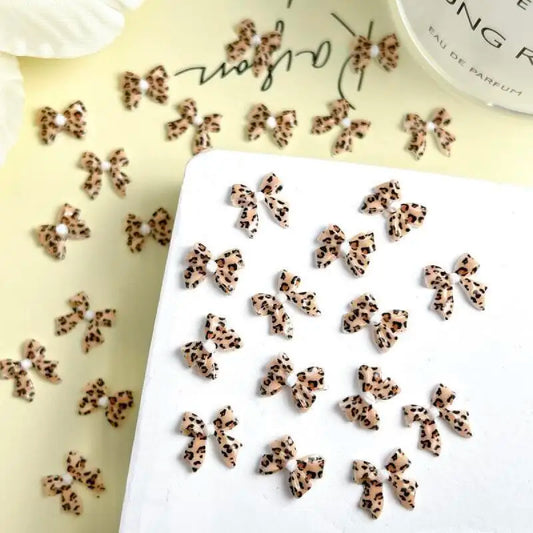 20-piece Blushimmer Maillard color ribbon bow nail art set with leopard print resin charms and DIY clips for nail decoration.