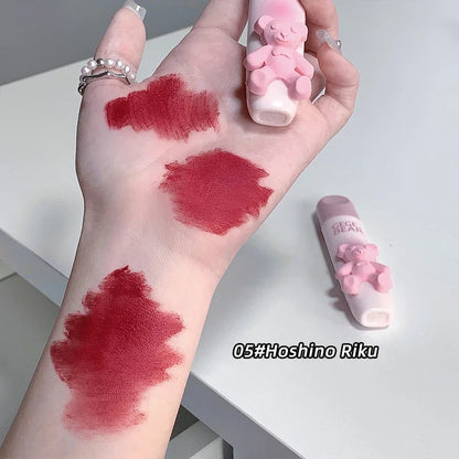 Blushimmer cute bear lip glaze and matte velvet lipstick with whitening lip cream, held in hand, showcasing colorful lip makeup.