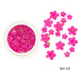 White acrylic flower nail art decorations with mixed size rhinestones and colorful gems for DIY manicure designs.