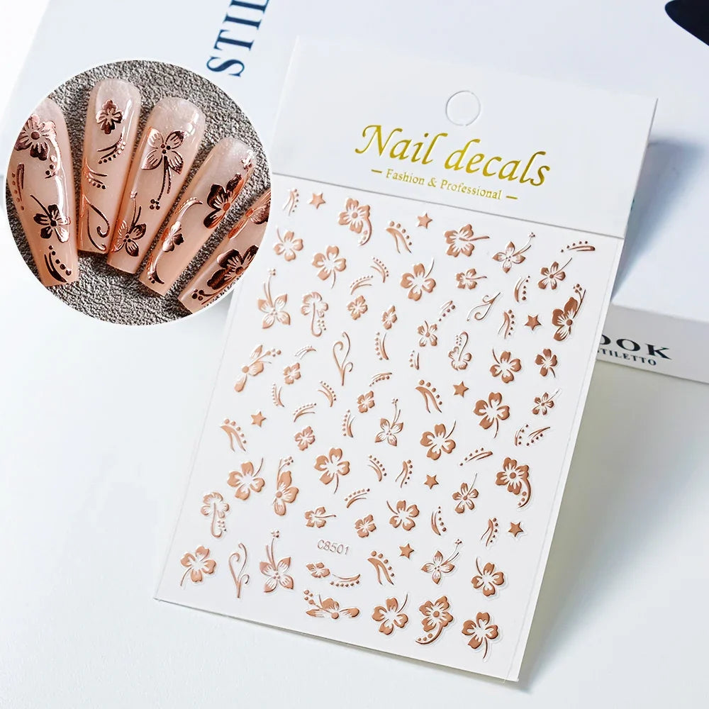 White and black 3D hibiscus flower nail stickers with pink and gold accents, adhesive floral decals for nail art decoration by Blushimmer.