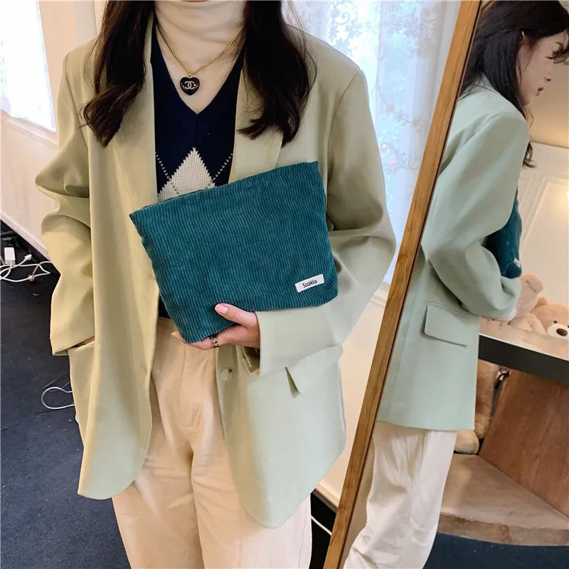 Blushimmer corduroy makeup bag for women, large capacity for lipstick, phone, and essentials, handheld design with stylish texture.