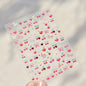Close-up of Blushimmer cherry-shaped 5D nail art stickers with shiny crystals and bowknot design, ideal for DIY manicure decoration.