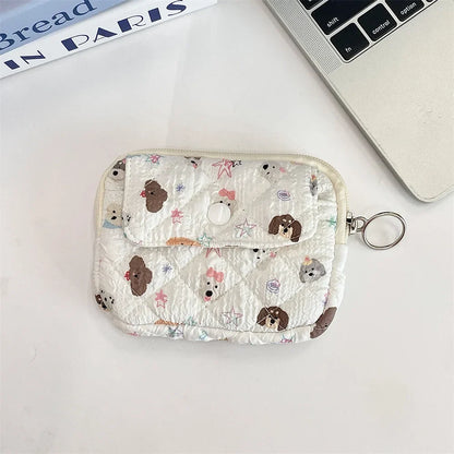 Cute cartoon travel cosmetic and makeup pouch by Blushimmer, featuring compartments for lipstick, earphones, and cards.