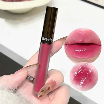 Berry red translucent lip gloss by Blushimmer with hydrating, water-light texture and nude brown jelly lipstick appearance.