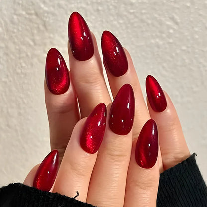 Set of 24 glossy red cat's eye press-on almond nails in nude color with charms, designed for easy wear and removal by girls.