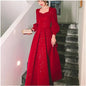 Elegant red luxury ceremony gown by Luxlife Brands featuring intricate details and flowing fabric for special occasions.