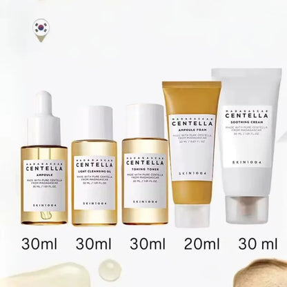 SKIN1004 Madagascar Centella travel skincare kit with toner, ampoule, soothing cream, cleansing oil, and foam in mini bottles.
