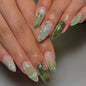 Set of 24 glossy almond false nails by Blushimmer with dark green forest mushroom pattern, gold sequins, and French style design.