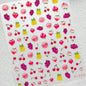 Close-up of cute red cherry bowknot 5D nail art stickers with shiny rhinestones, perfect for DIY manicure decoration.