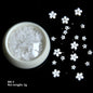 White acrylic flower nail art decorations with mixed size red and blue rhinestones for DIY manicure, by Blushimmer.