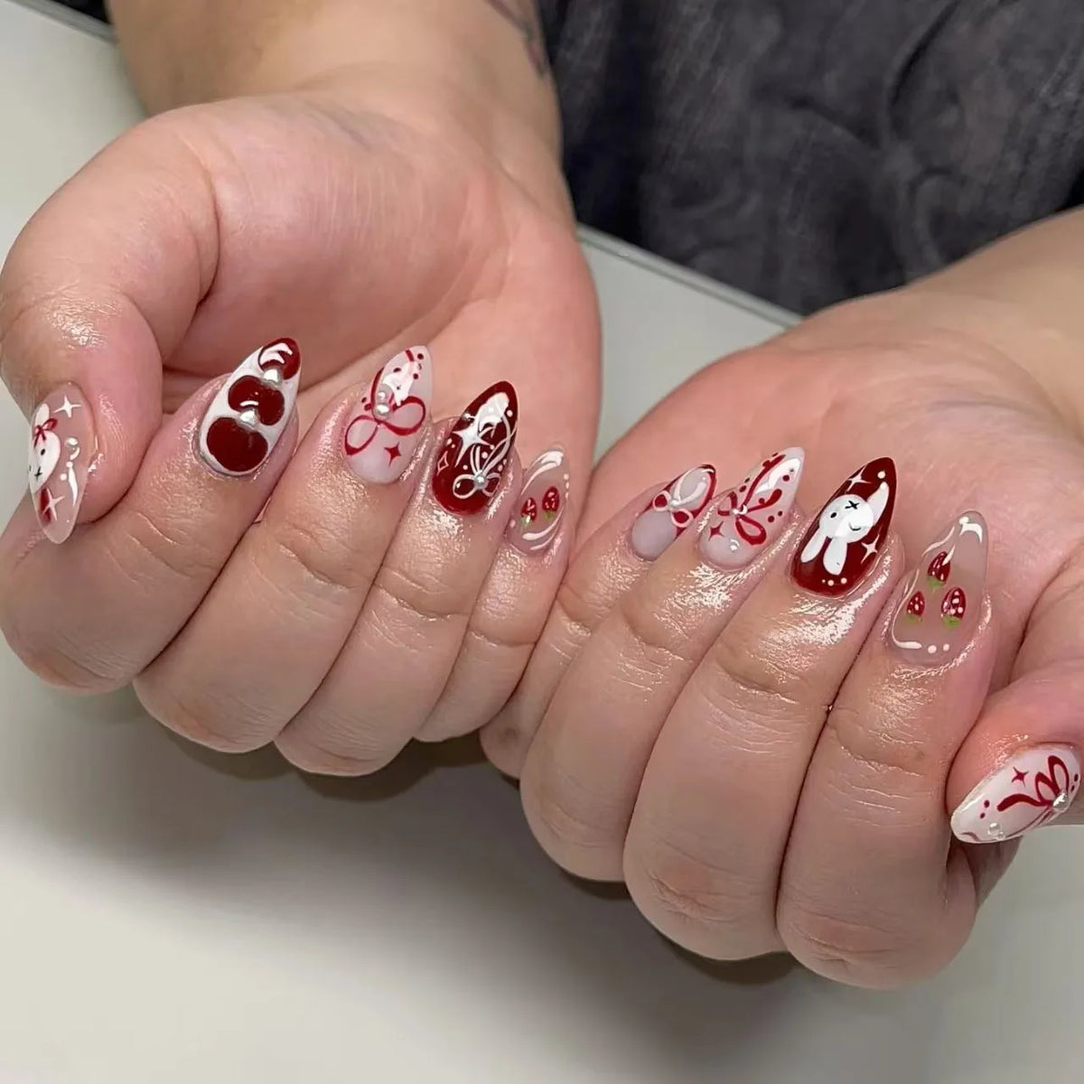 Blushimmer 24-piece wine red almond press-on nails featuring cartoon rabbit, bowknot, plaid, pearl designs, and French style.