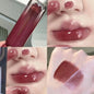 Blushimmer smoked grape purple red lip gloss with moisturizing liquid lipstick and clear tint, reflecting in a mirror.