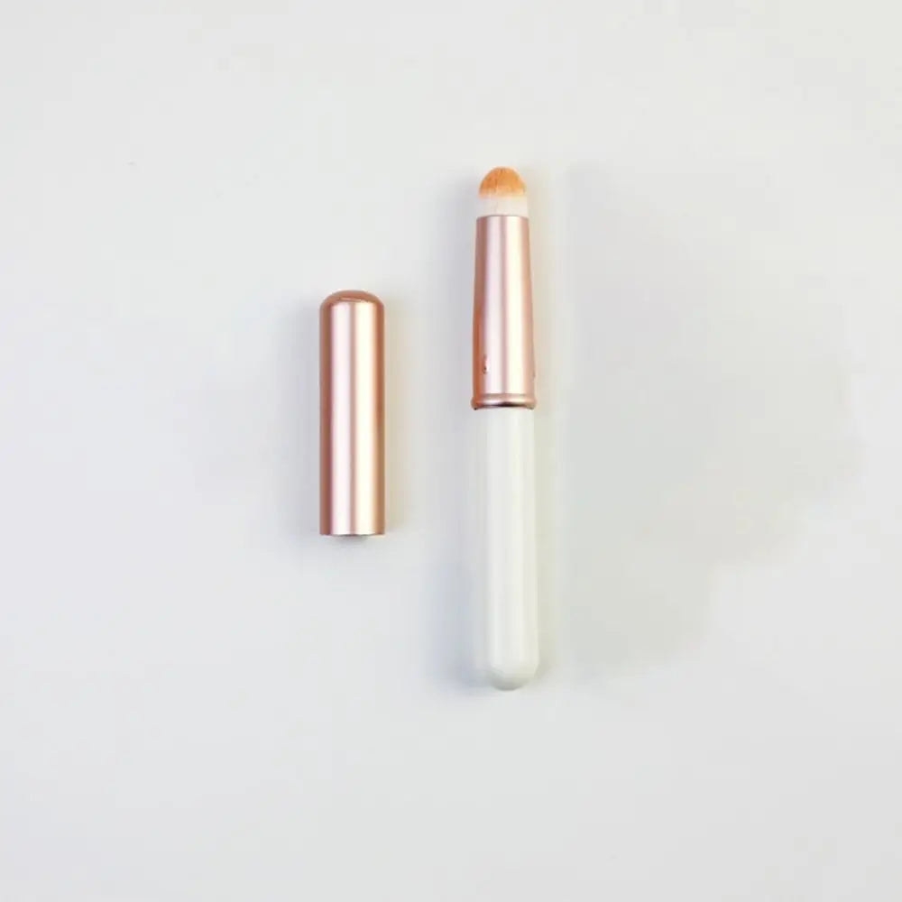 Blushimmer portable gold and silver lipstick makeup brush pen with metal handle and protective cap for lip gloss application.