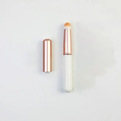 Blushimmer portable gold and silver lipstick makeup brush pen with metal handle and protective cap for lip gloss application.