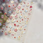 Close-up of Blushimmer Juicy Red Cherry Bowknot 5D nail art stickers with shiny crystal rhinestones for DIY manicure decoration.