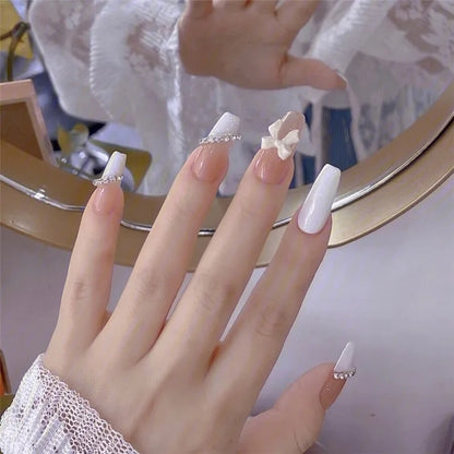 Set of 24 Blushimmer dark wind gradient long white bow nail patches, showcasing elegant fake nail designs in a box.