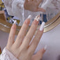 Set of 24 Blushimmer dark wind gradient long white bow nail patches, showcasing elegant fake nail designs in a box.
