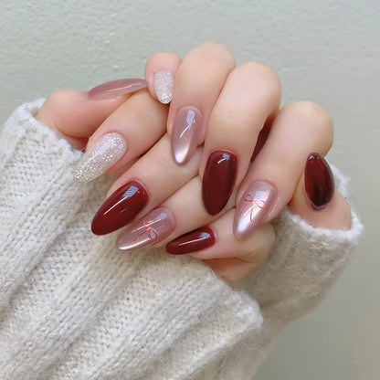 Set of 24 glossy red cat's eye press-on nails by Blushimmer, almond-shaped, full cover false nails with nude color and charms.