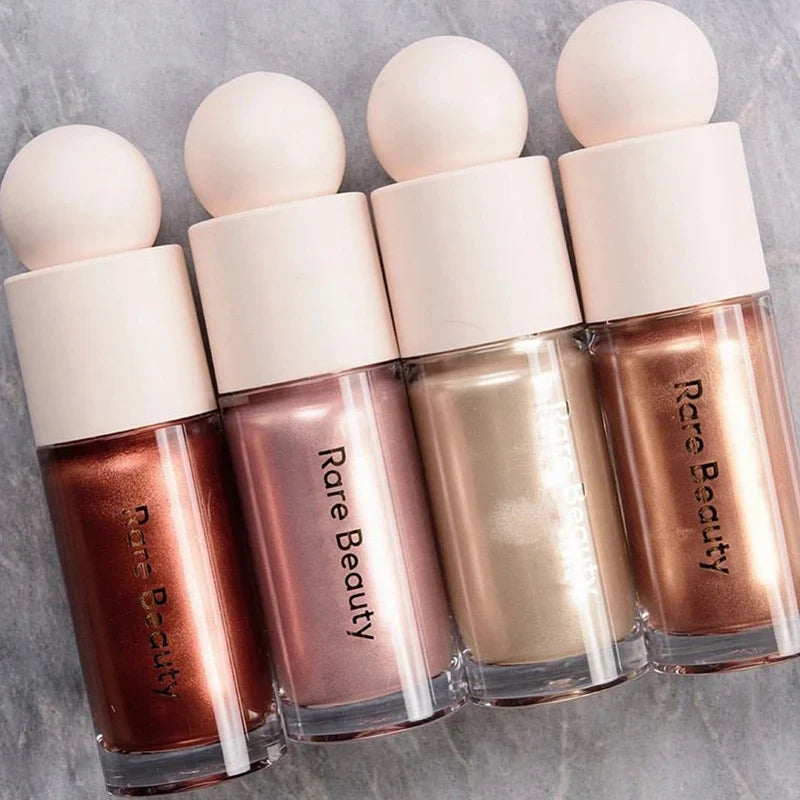 Blushimmer Rare Beauty Positive Light liquid contour and luminizer, face blush and shimmer makeup with a shiny lipstick finish.