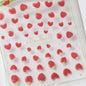 Close-up of shiny red cherry bowknot 5D nail art stickers with crystal rhinestones, perfect for DIY manicure decoration by Blushimmer.