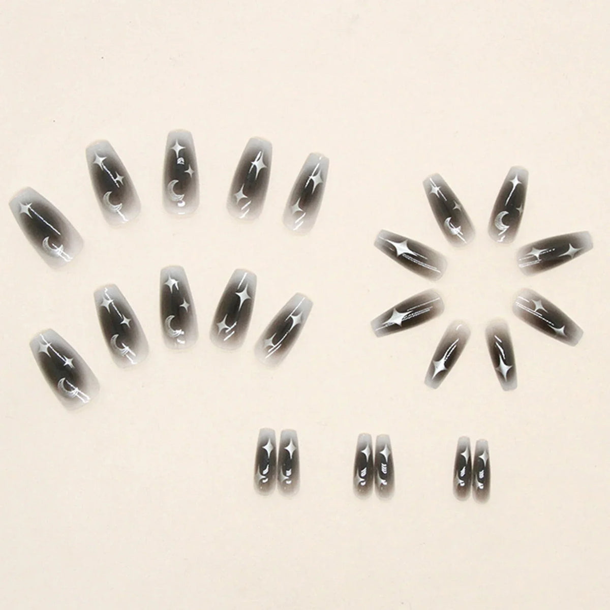 Set of 24 Blushimmer Y2k star press on nails featuring gradient black color, moon designs, and mid-length coffin shape.