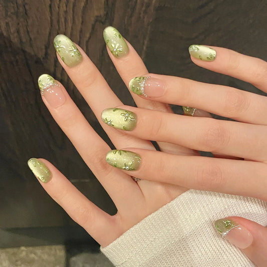 Set of 10 green flower print handmade press on nails by Blushimmer with glitter, short oval shape, and green cat eye design.